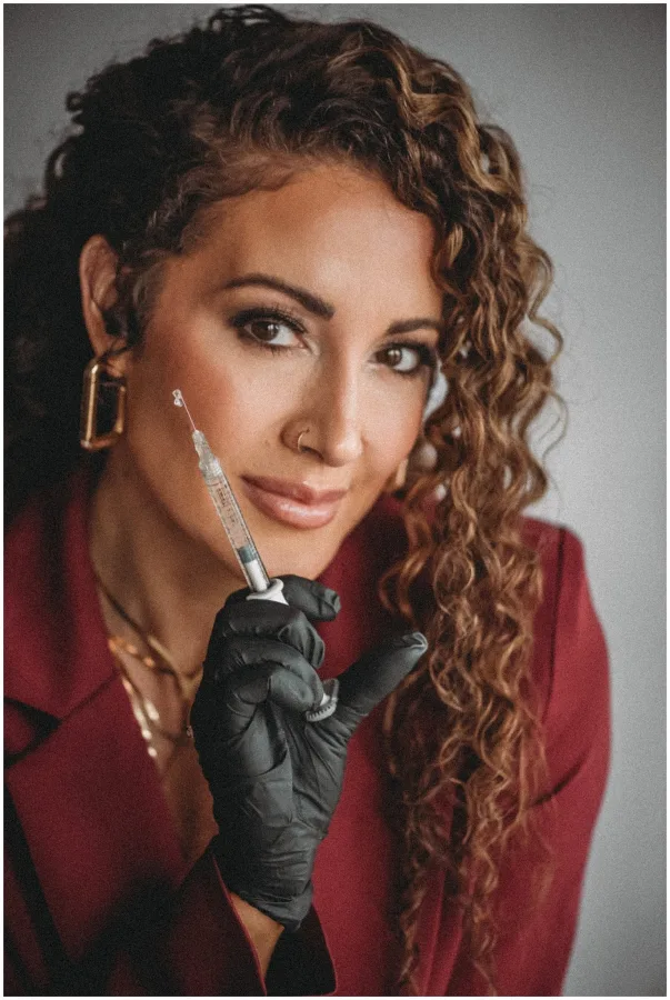 Long defined curls worn loose, in a deep red blazer