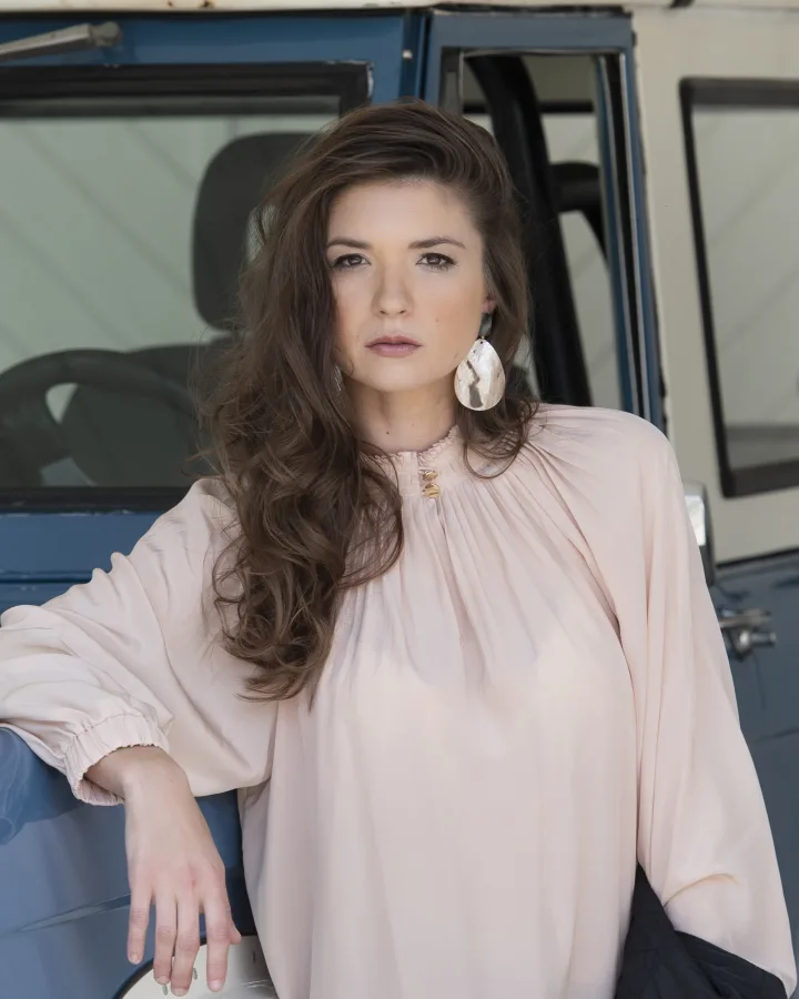 Long brunette hair swept over one shoulder in soft waves